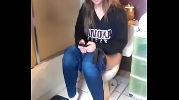 Girl on the toilet while using phone